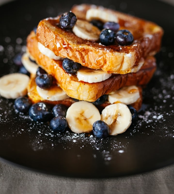 French toast topped with bananas and blueberries.
